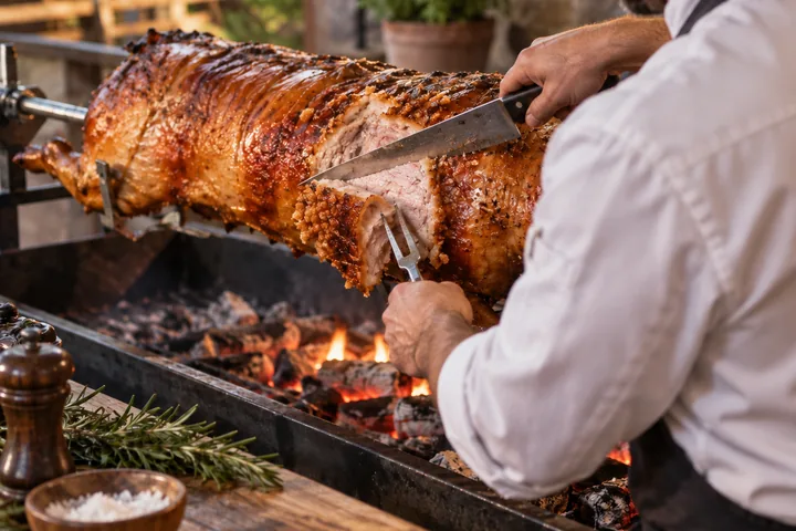 Spanferkel vom Grill wird frisch angeschnitten – Partyservice Kroll